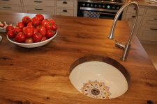 על האי כיור מצויר עבודת יד שקוע במשטח אלון